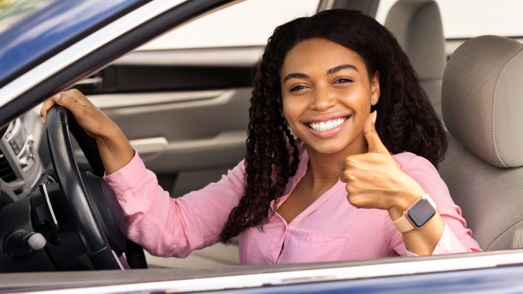 Black woman giving a thumbs up after a car service at a dealership working with WorkFlow 360